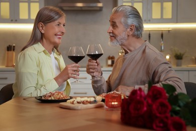 Photo of Affectionate senior couple having romantic dinner at home