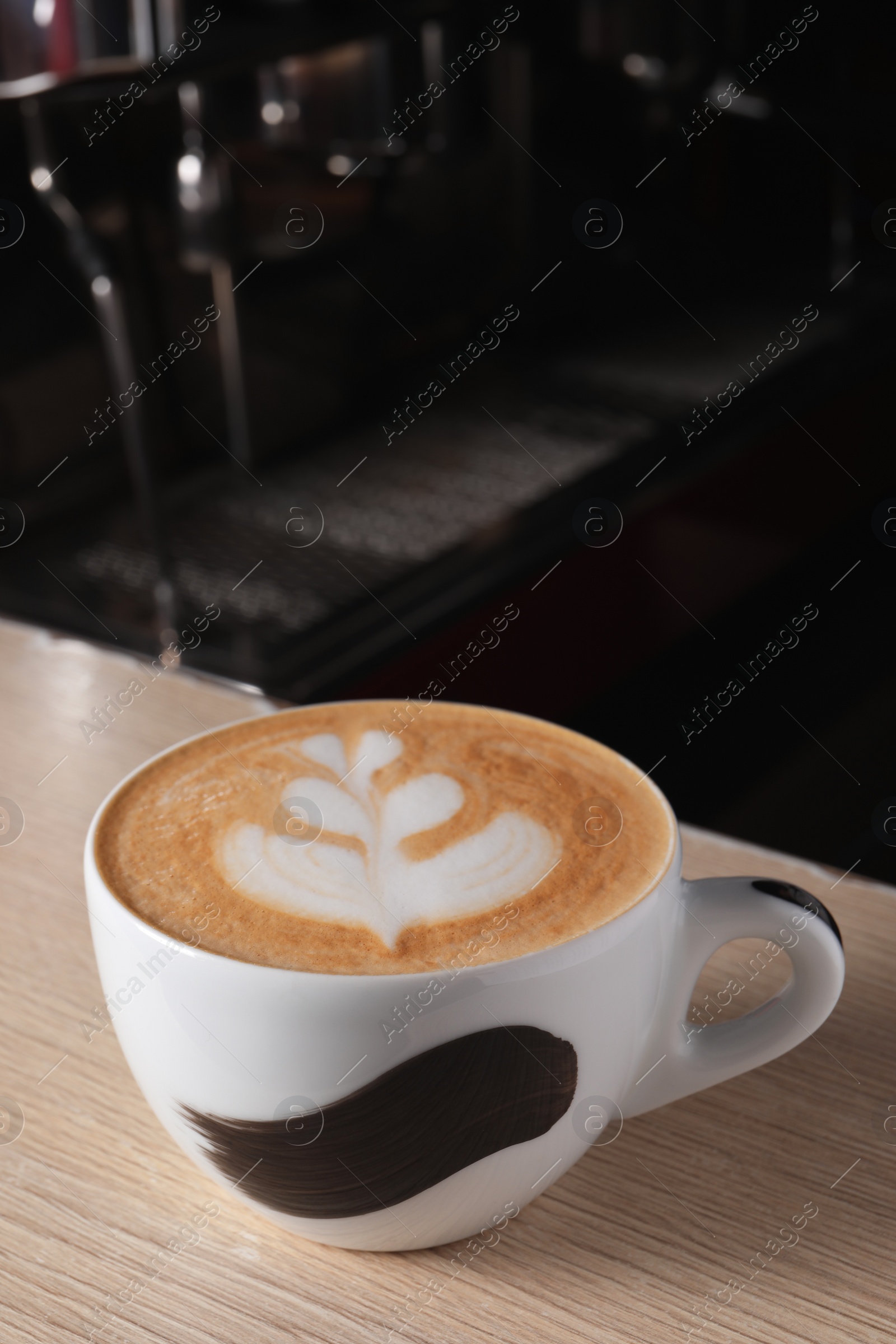 Photo of Cup of fresh aromatic coffee on wooden counter in cafe