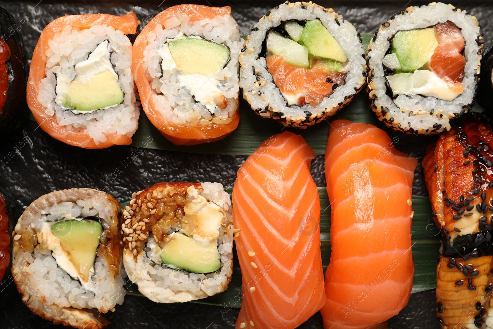 Photo of Set of delicious sushi rolls on board, top view