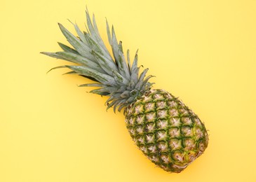 Photo of Delicious ripe pineapple on yellow background, top view
