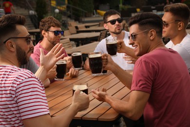 Friends with glasses of beer in outdoor cafe