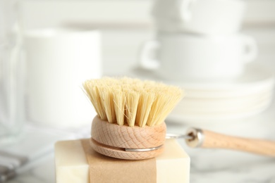 Photo of Cleaning brush and soap bar for dish washing, closeup