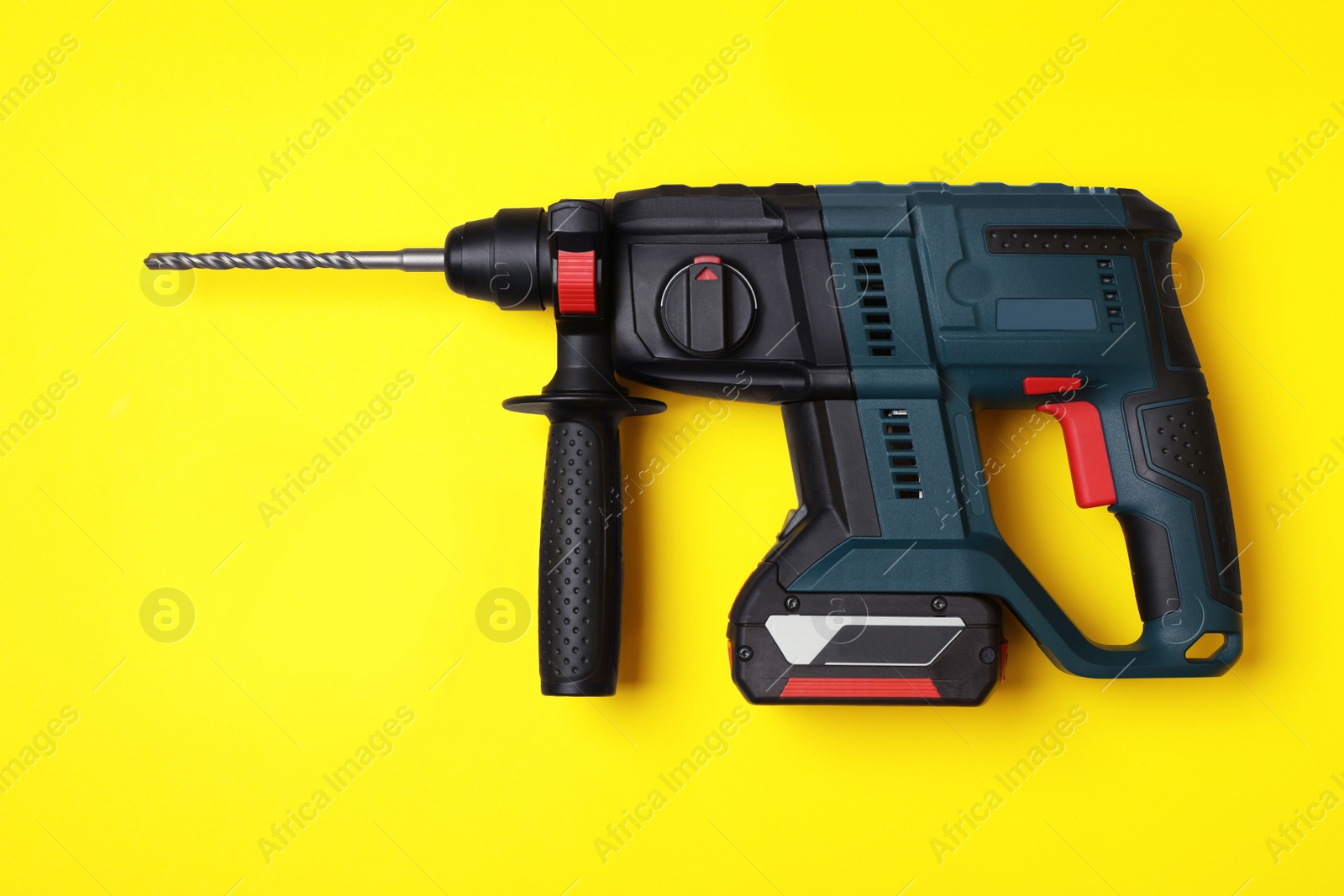 Photo of Modern electric power drill and different bits on yellow background, flat lay