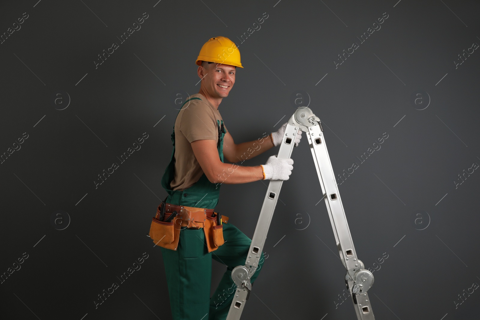 Photo of Professional constructor climbing ladder on black background