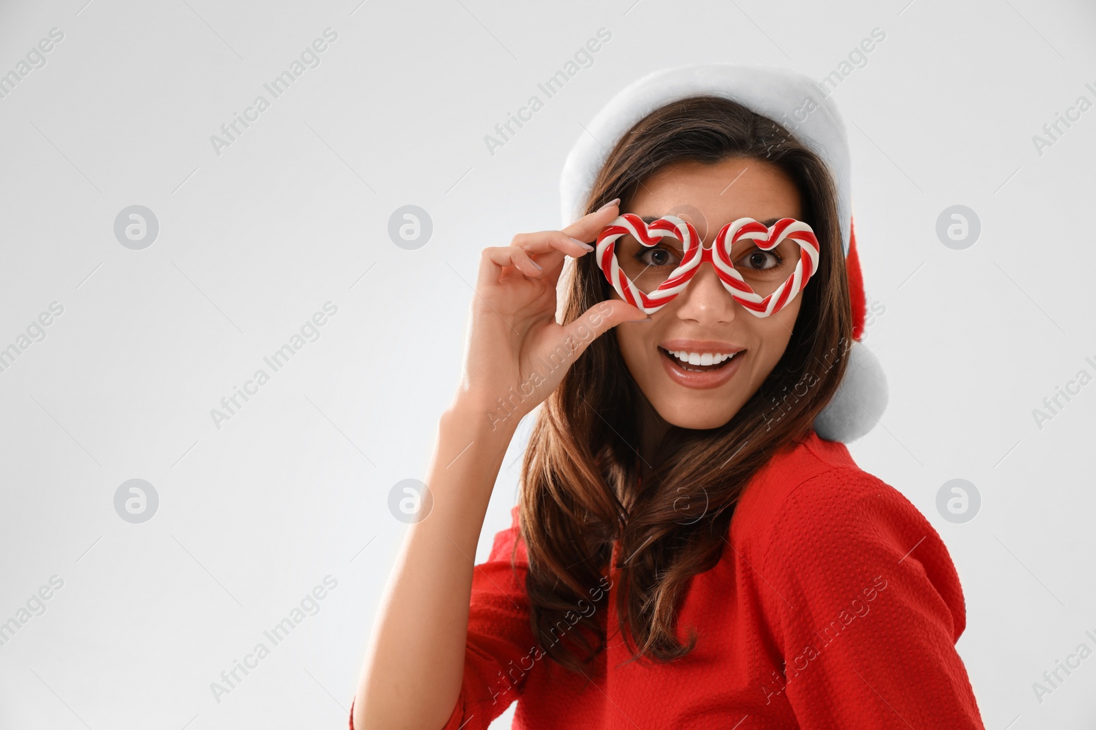 Photo of Beautiful woman wearing Santa hat and festive glasses on white background. Christmas party