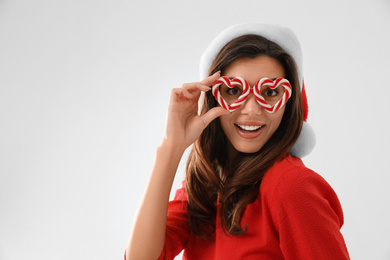 Photo of Beautiful woman wearing Santa hat and festive glasses on white background. Christmas party