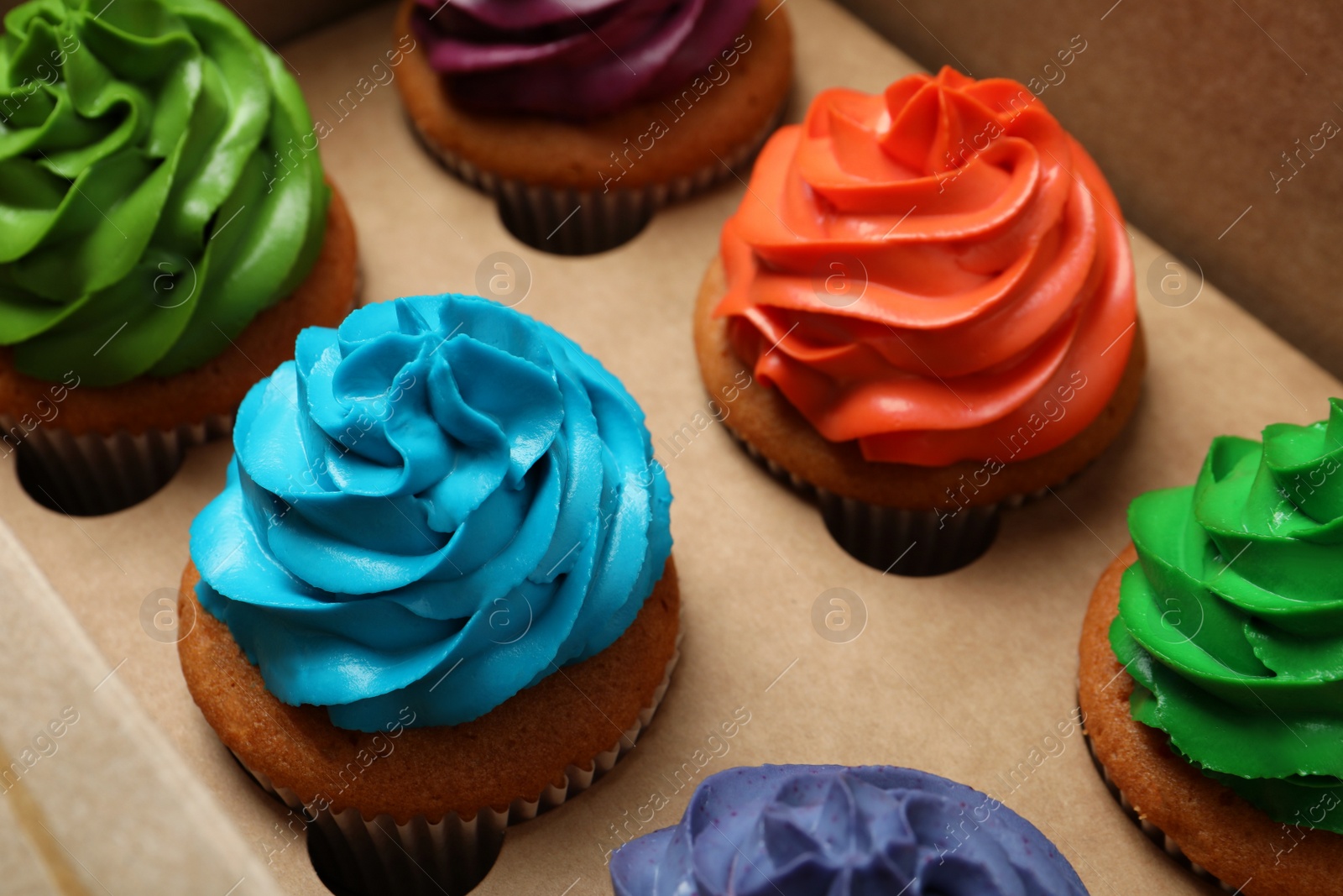 Photo of Different cupcakes with cream in box, closeup