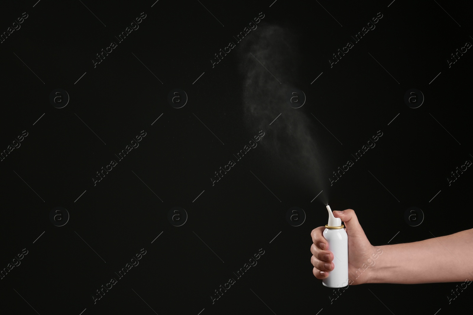 Photo of Nasal congestion. Woman spraying remedy from bottle on black background, closeup with space for text