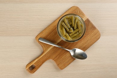 Canned green beans on wooden table, top view