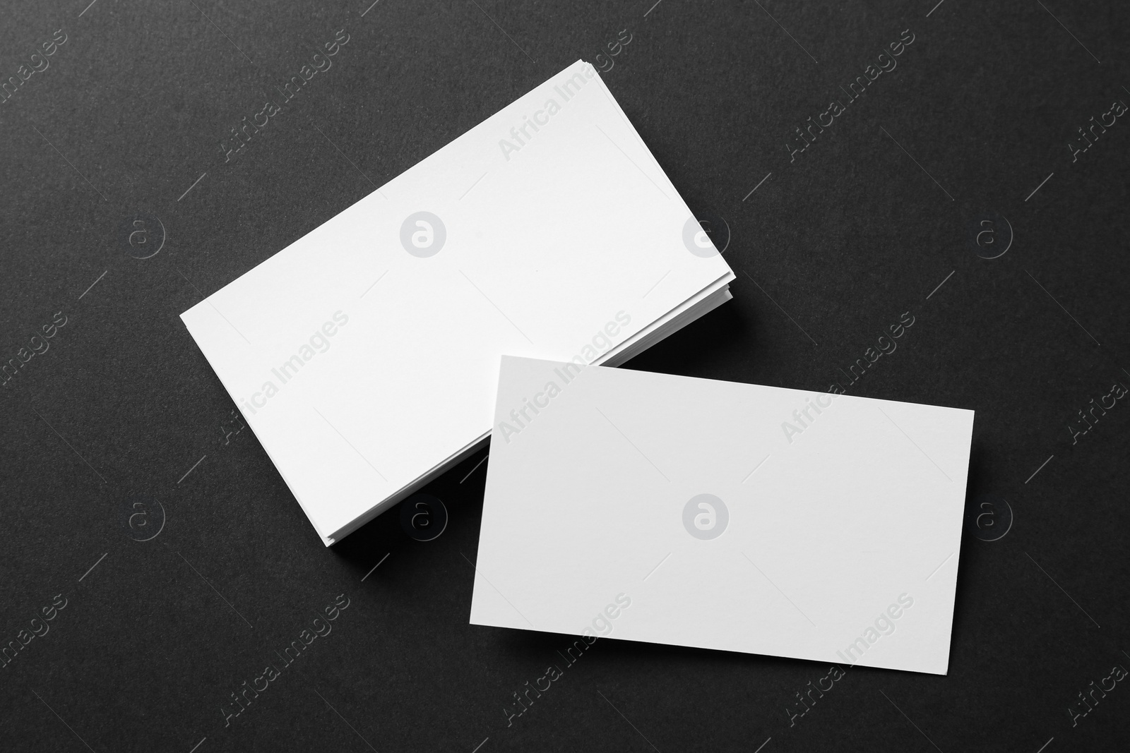 Photo of Blank business cards on black background, flat lay. Mockup for design