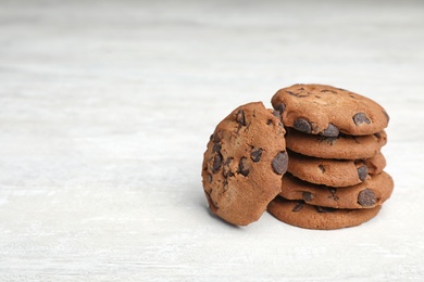 Photo of Stack of tasty chocolate cookies on light table, space for text