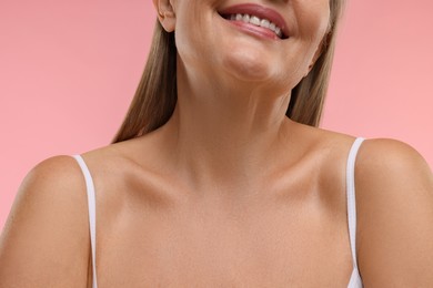 Photo of Mature woman with healthy skin on pink background, closeup