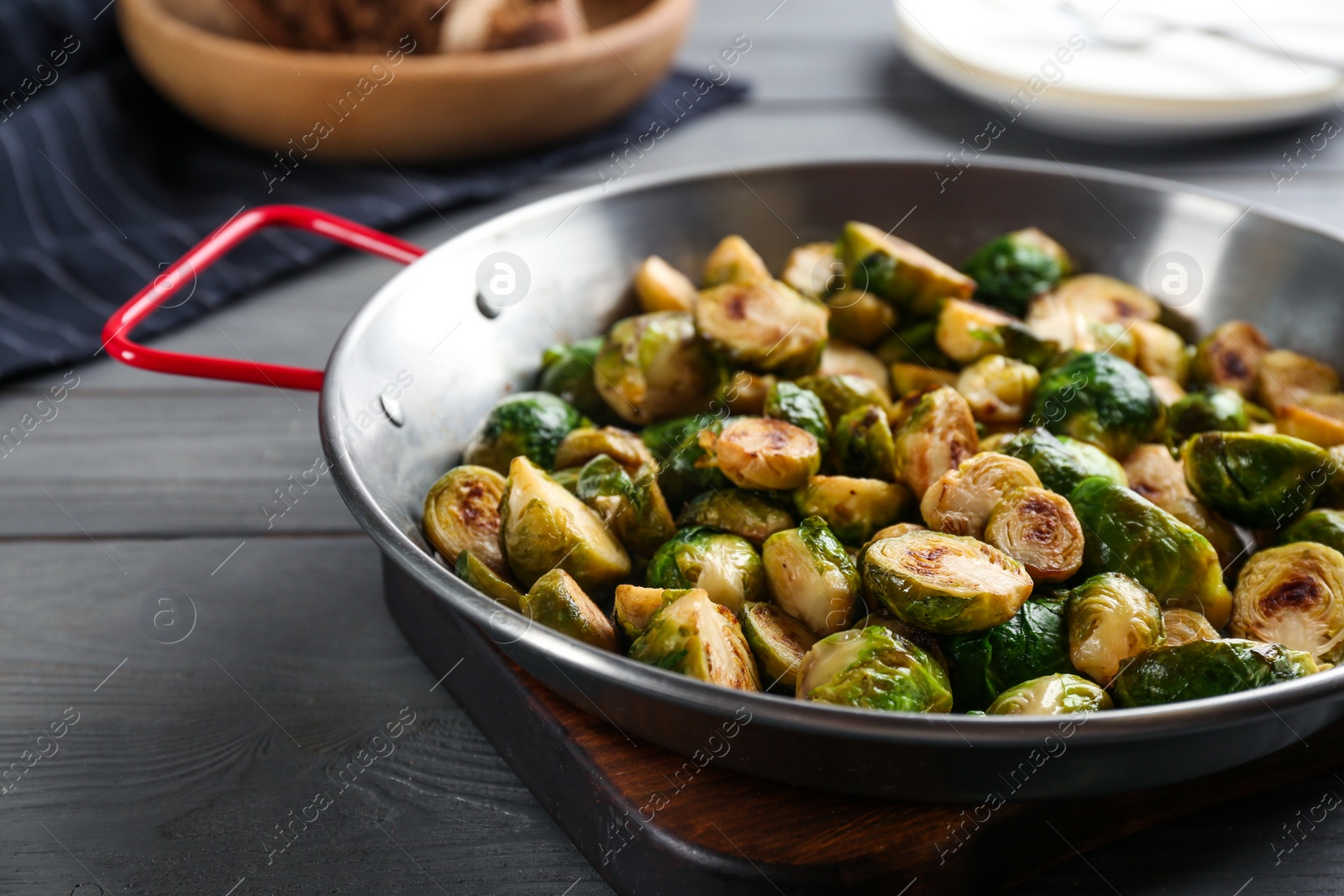 Photo of Delicious roasted brussels sprouts on grey wooden table, closeup