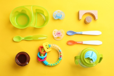 Flat lay composition with baby food and accessories on color background