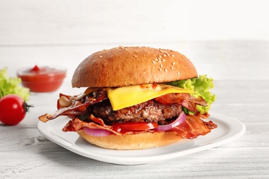 Photo of Tasty burger with bacon on plate