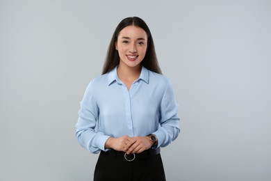 Portrait of beautiful young woman on light grey background