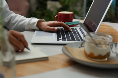 Blogger working with laptop in cafe, closeup