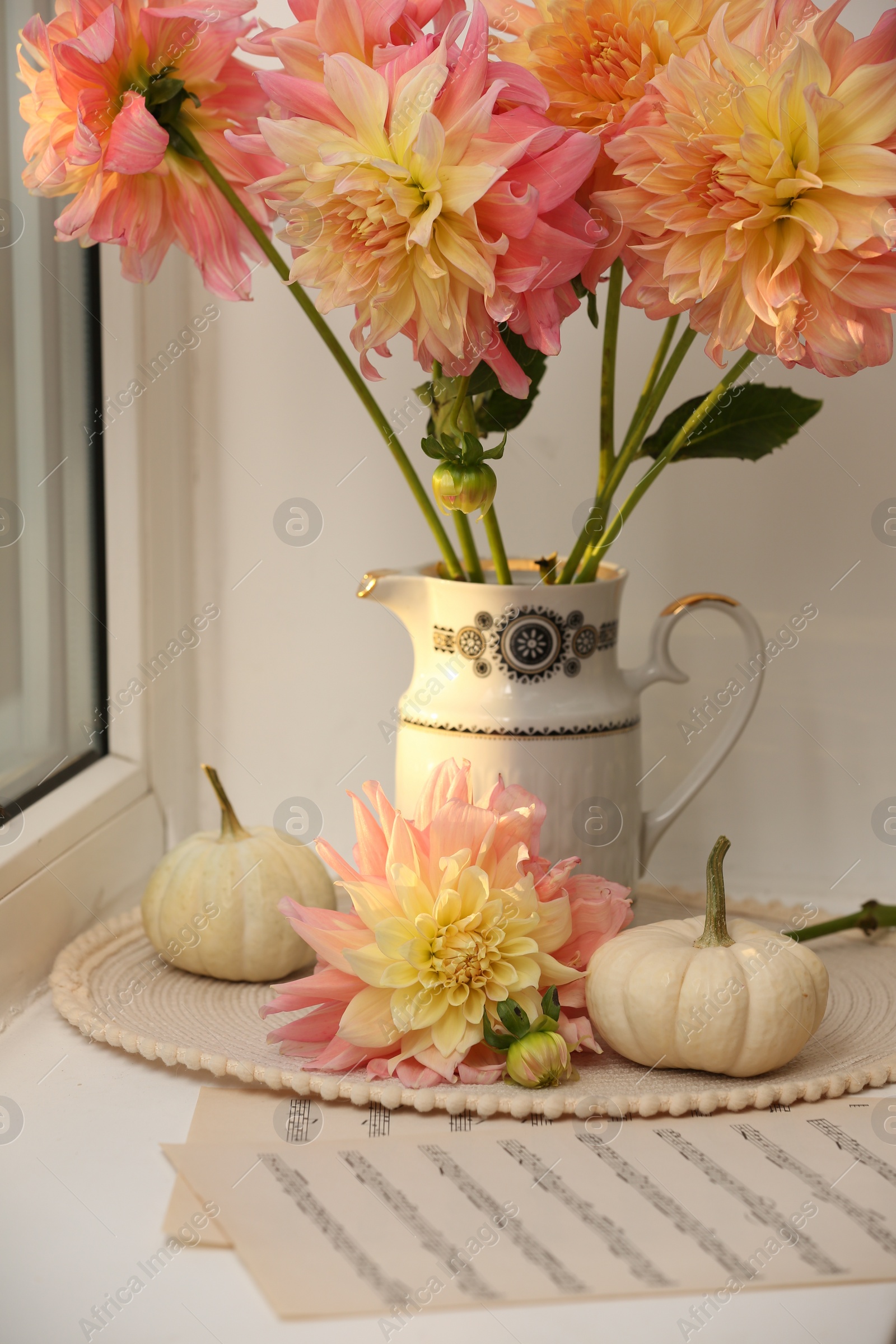 Photo of Beautiful composition with dahlia flowers on windowsill. Autumn atmosphere