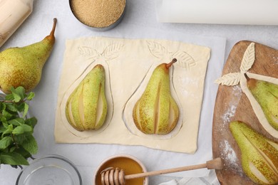 Raw dough with fresh pears, honey and mint on white table, flat lay