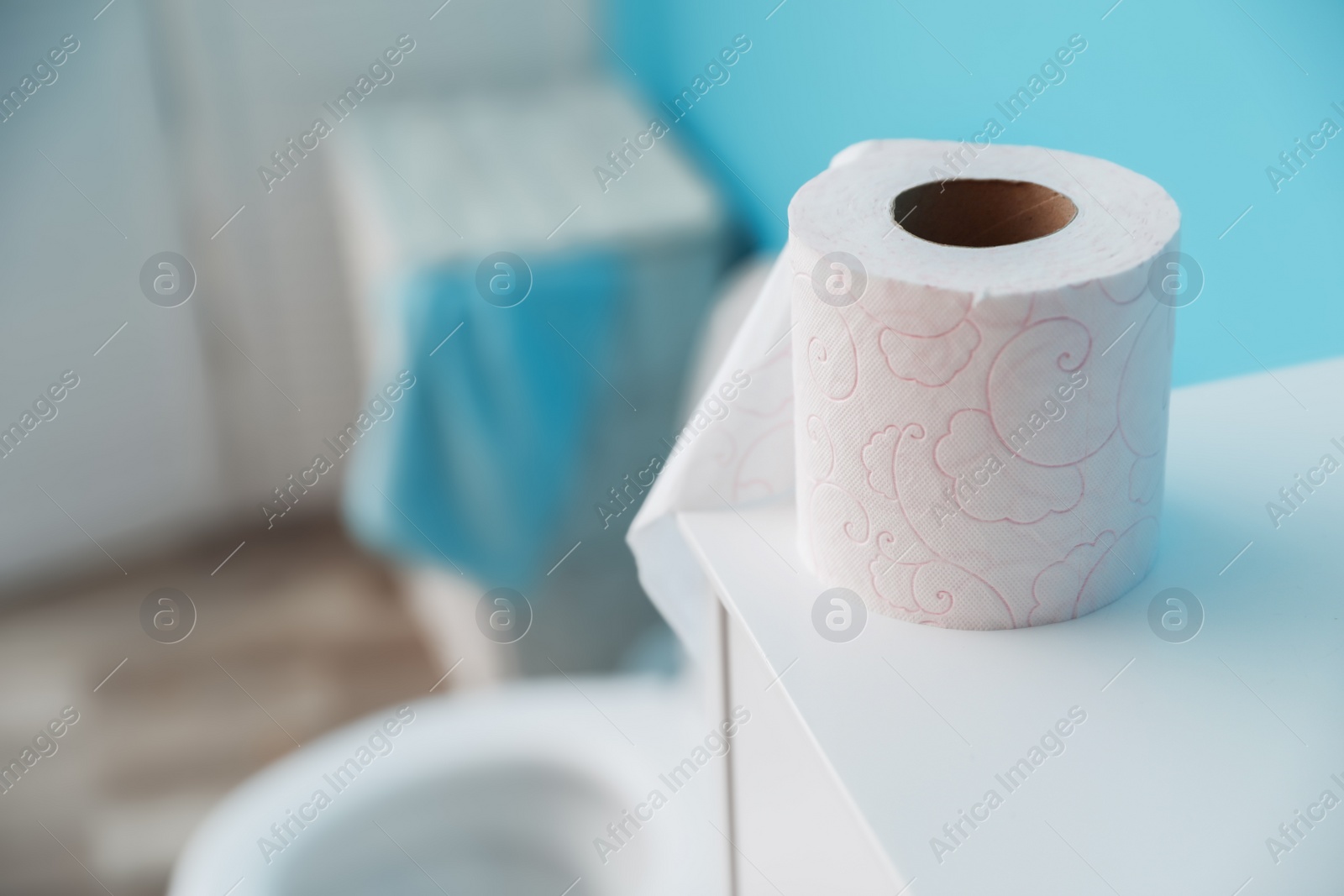 Photo of Toilet paper roll on cabinet in bathroom. Space for text