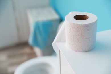 Photo of Toilet paper roll on cabinet in bathroom. Space for text