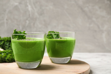 Photo of Tasty kale smoothie on marble table, closeup