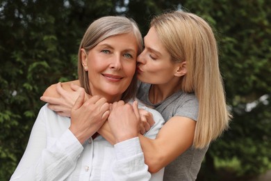 Happy mature mother and her daughter outdoors