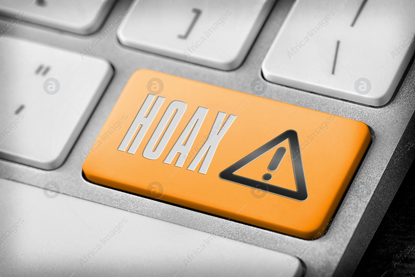 Image of Orange button with word Hoax and warning sign on computer keyboard, closeup