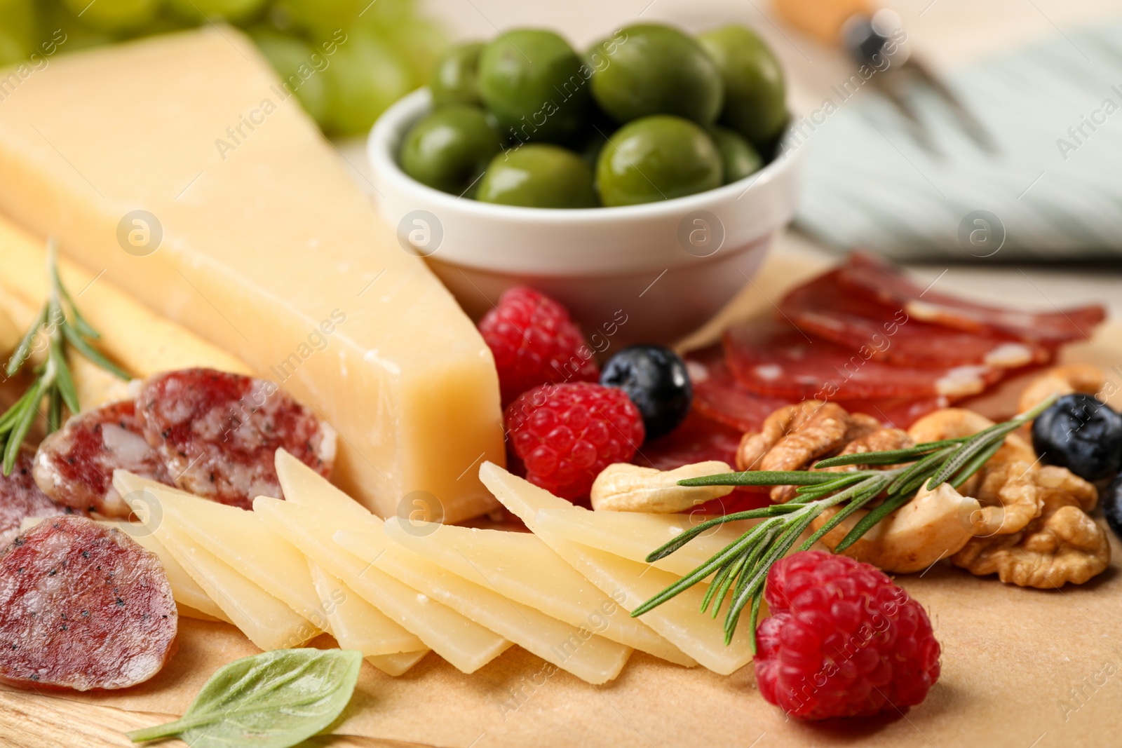 Photo of Snack set with delicious Parmesan cheese on wooden board, closeup