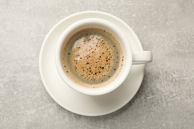 Photo of Cup of aromatic coffee on light grey table, top view