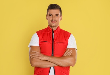 Photo of Portrait of happy young courier on yellow background