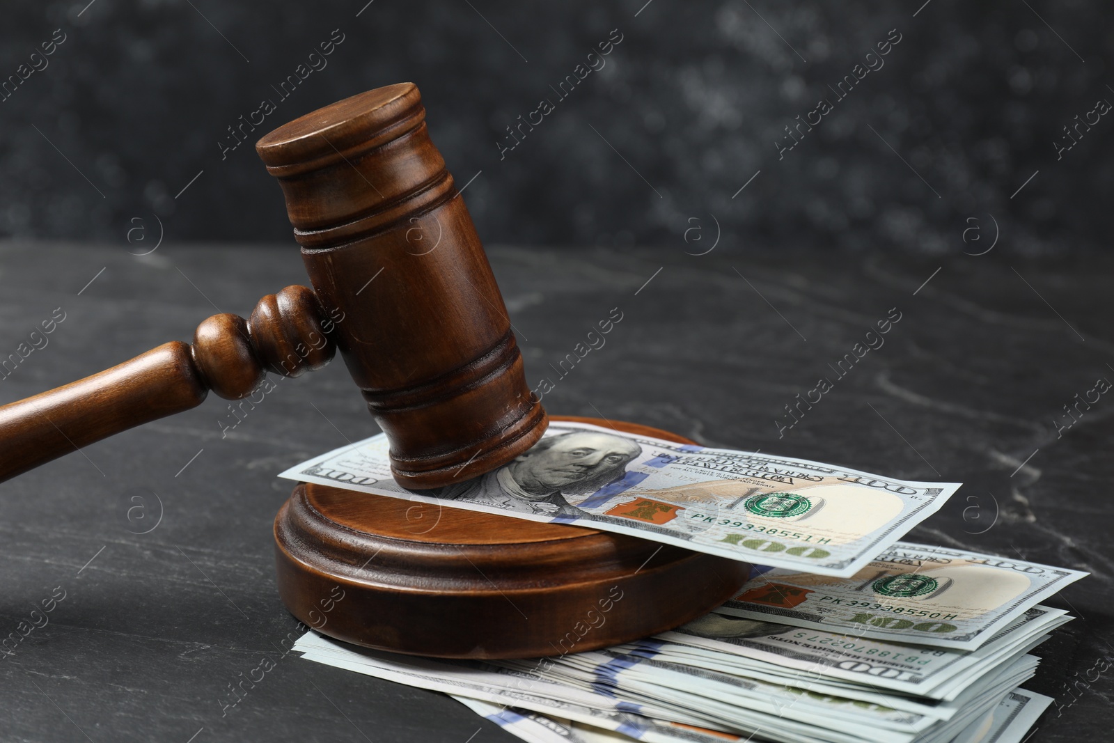 Photo of Judge's gavel and money on dark grey table, closeup
