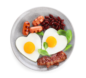 Photo of Plate of tasty breakfast with heart shaped fried eggs isolated on white, top view
