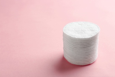 Photo of Stack of cotton pads on color background. Space for text