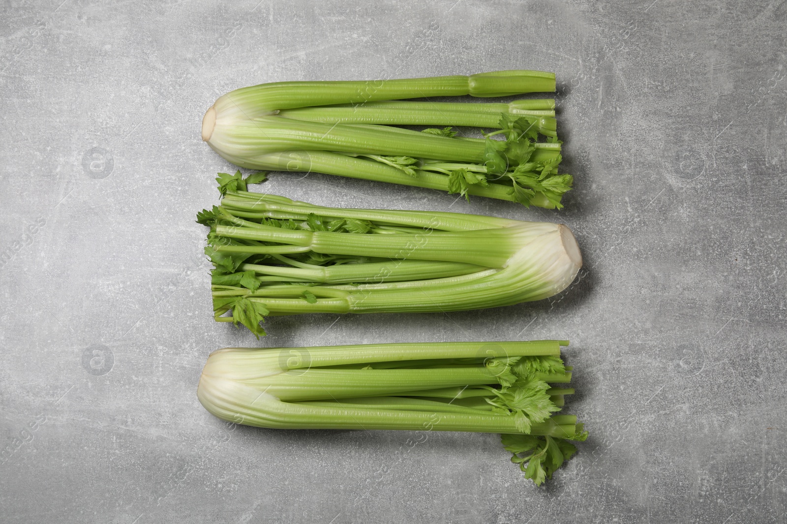 Photo of Fresh ripe green celery on grey table, flat lay