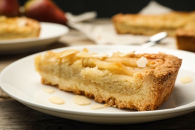 Photo of Piece of delicious sweet pear tart on table, closeup