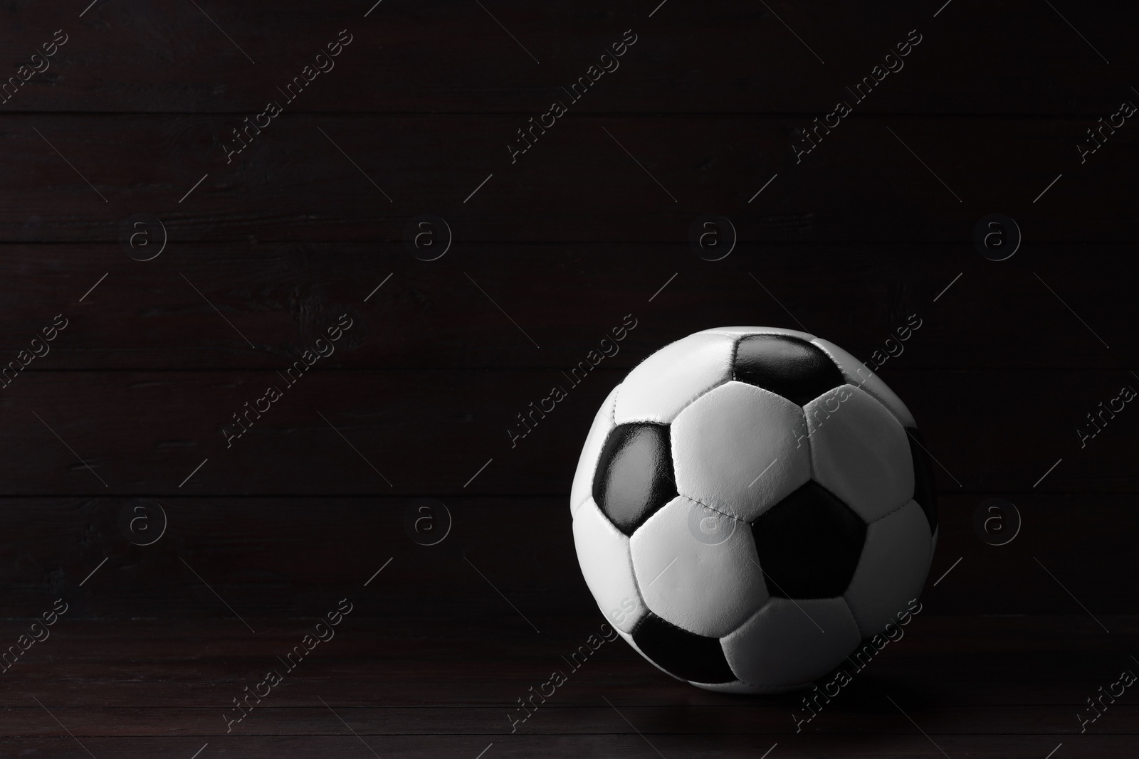 Photo of One soccer ball on wooden background, space for text