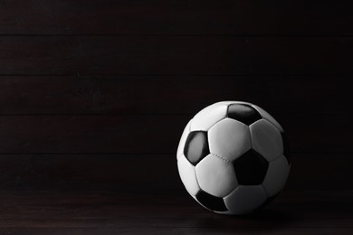 One soccer ball on wooden background, space for text
