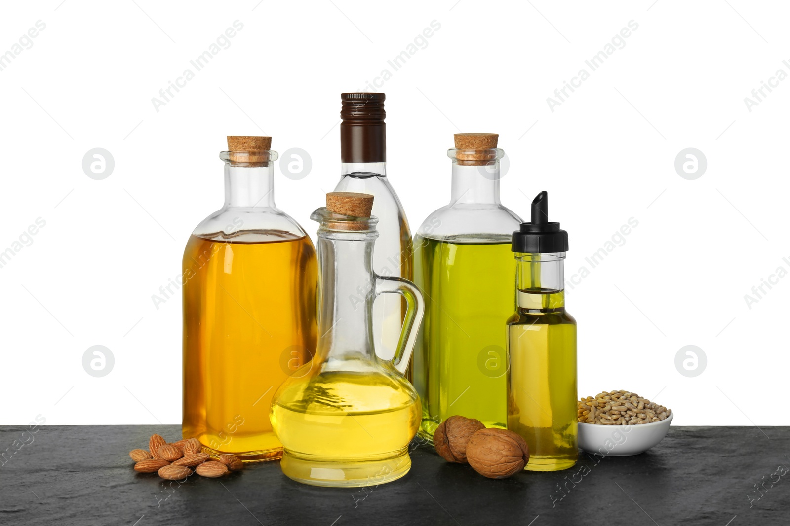 Photo of Vegetable fats. Different cooking oils and ingredients on wooden table against white background