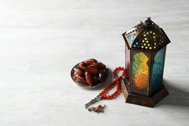 Photo of Muslim lamp, dates and misbaha on light background. Fanous as Ramadan symbol