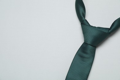 Photo of Green necktie on light background, top view. Space for text