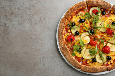Photo of Delicious vegetable pizza on grey table, top view. Space for text