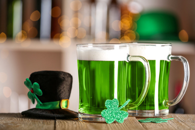 Photo of Green beer, clover and hat on wooden counter, closeup. St.Patrick's Day celebration