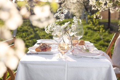 Beautiful table setting with spring flowers in garden on sunny day