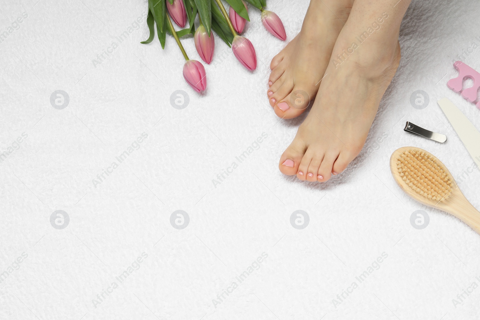 Photo of Closeup of woman with neat toenails after pedicure procedure on white terry towel, top view. Space for text