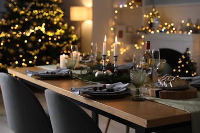 Christmas table setting with festive decor and dishware in room