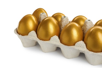 Photo of Many shiny golden eggs in carton on white background