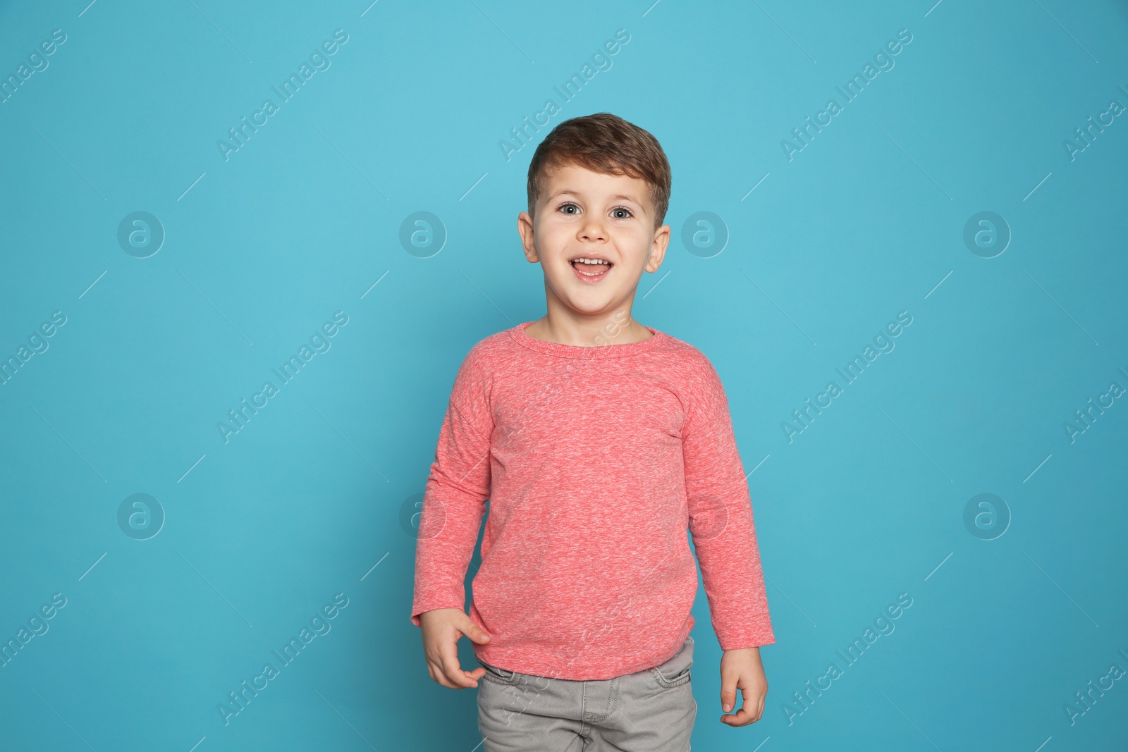 Photo of Portrait of little boy laughing on color background