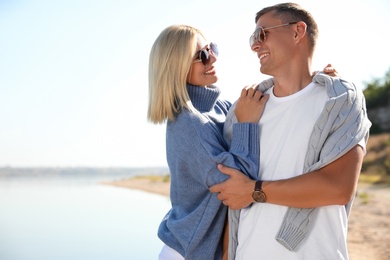 Photo of Happy couple in stylish sweaters on beach