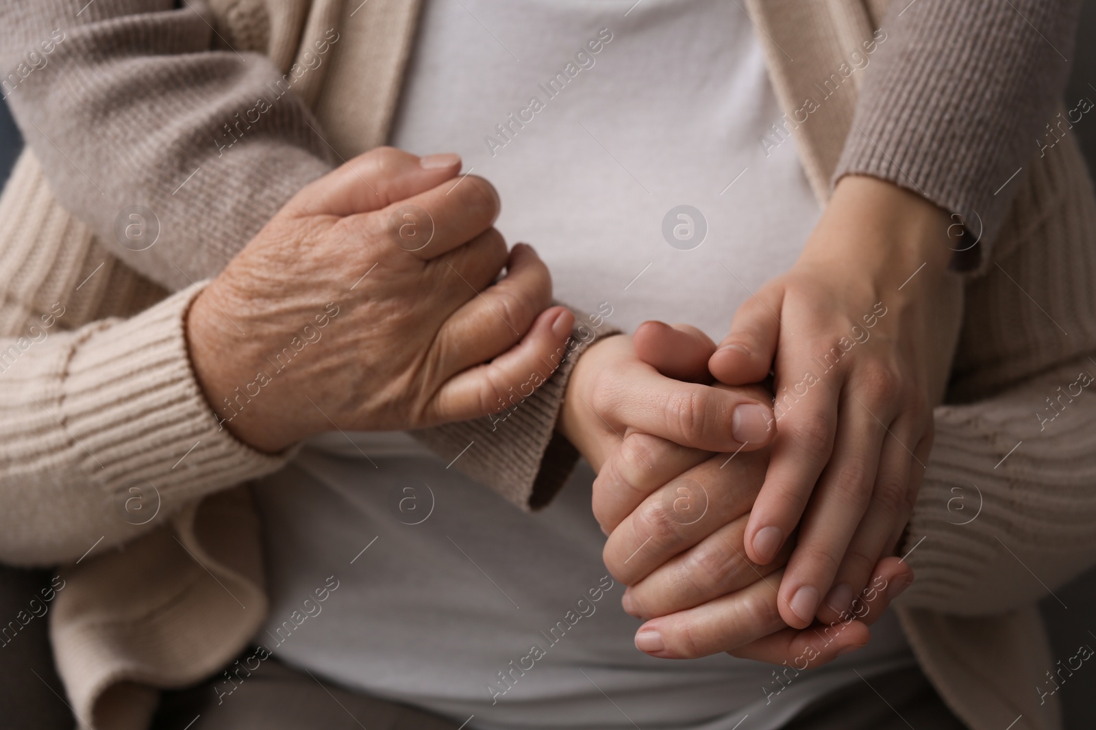 Photo of Young and elderly women hugging, closeup view